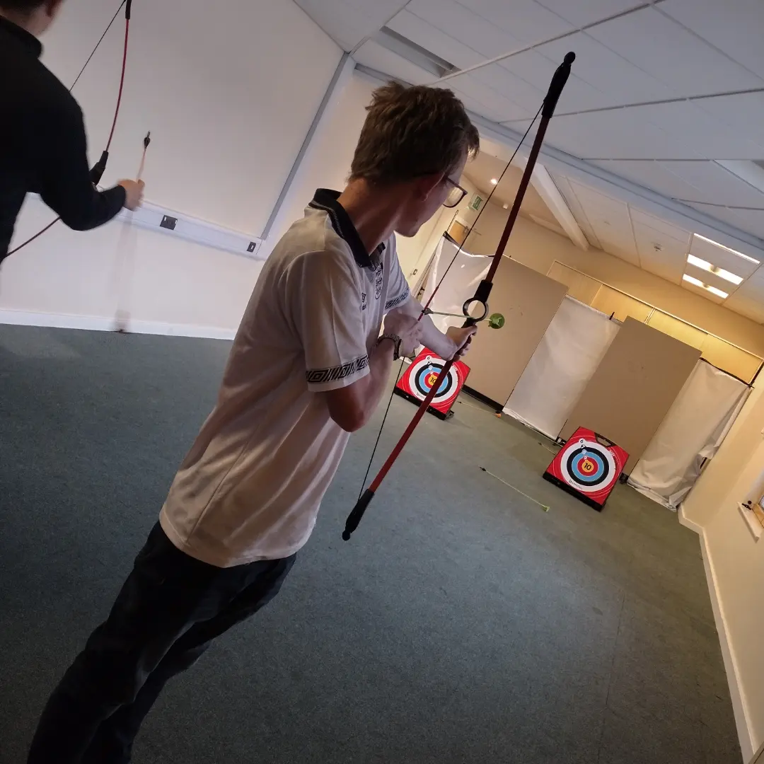 IMG_20231102_123119_935 A young male is trying indoor archery