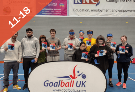 11 to 18. An image of a group of people smiling at the camera with a GoalBall UK sign in front of them.