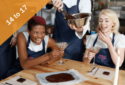 14 to 17. Two women laughing while holding chocolate drinks in glasses.