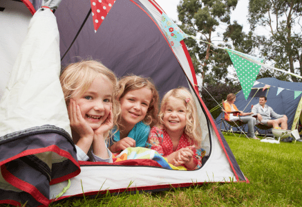 Children laughing and looking out of a tent.