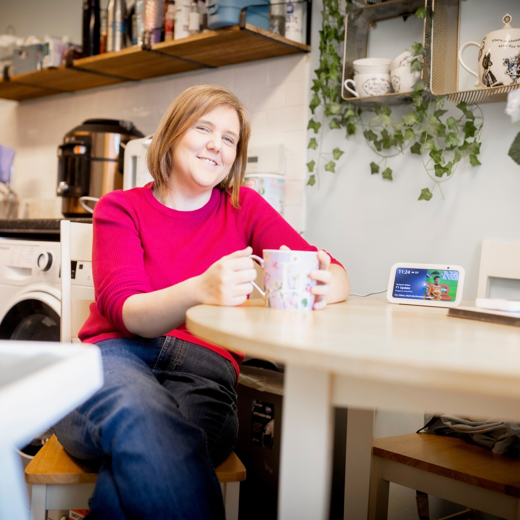laura fuller image Laura sits at a table holding a cup of tea and smiling