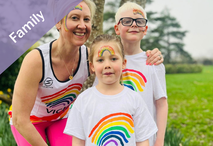 Family wearing rainbow logo VICTA T-shirts with rainbow face paint.