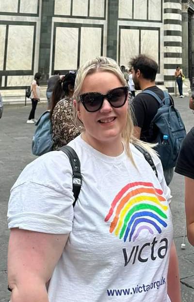 beth Beth wears a VICTA t-shirt and sunglasses as she smiles on a Florence trip