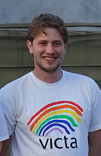 johnny-reed Johnny smiles to camera wearing a VICTA rainbow t-shirt
