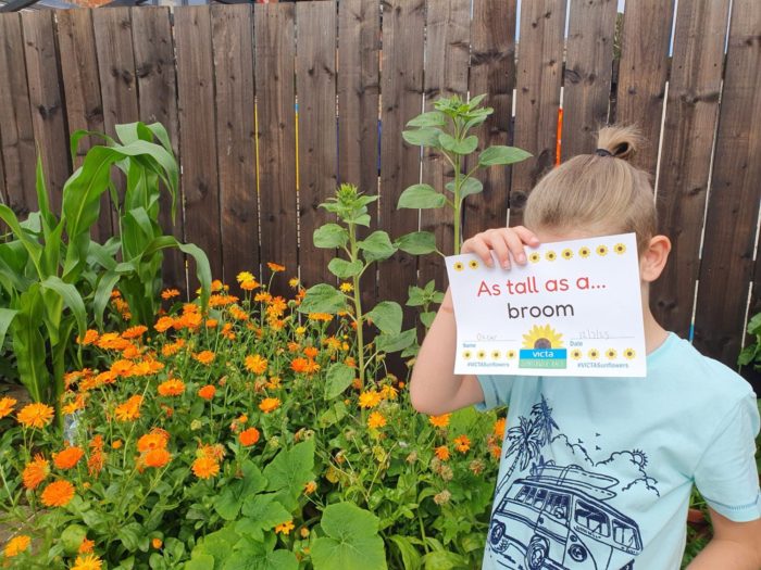 oscar-3 A boy holds a sign in front of his face, it reads 'as tall as a broom'