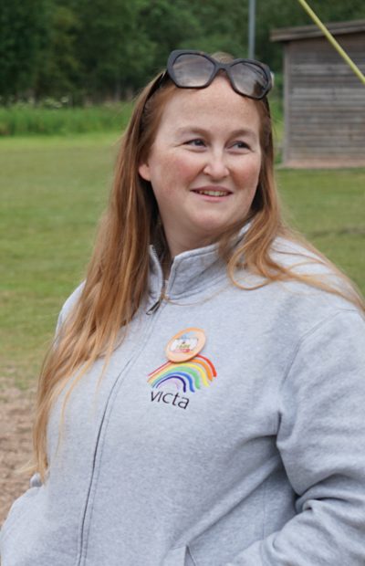 sage-crofts Sage wears a grey VICTA jumper and smiles while outside on a VICTA activity.