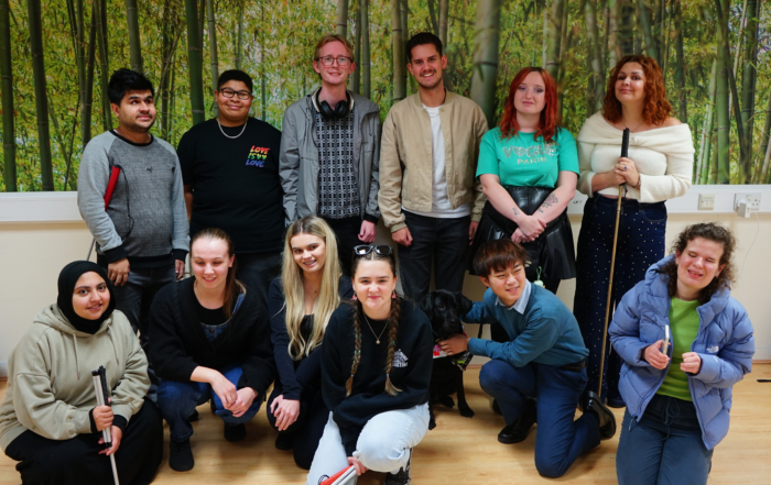 The Changemaker group gather for a group photo with speakers Seren & Toby. A guide dog also joins the photo.