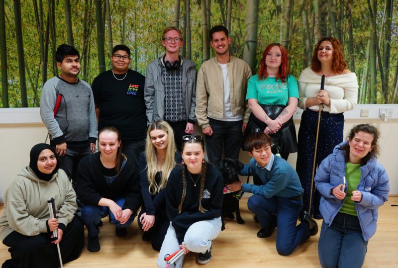 The Changemaker group gather for a group photo with speakers Seren & Toby. A guide dog also joins the photo.