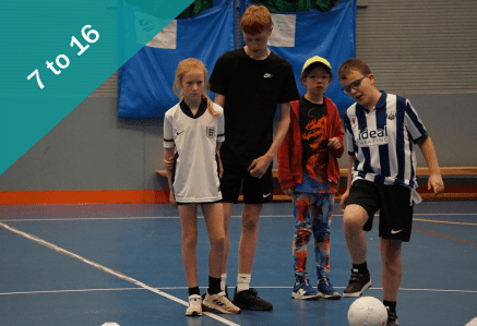 Four children playing partially sighted football.