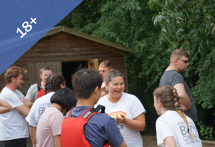 Volunteers having fun in a woodland setting with young people.