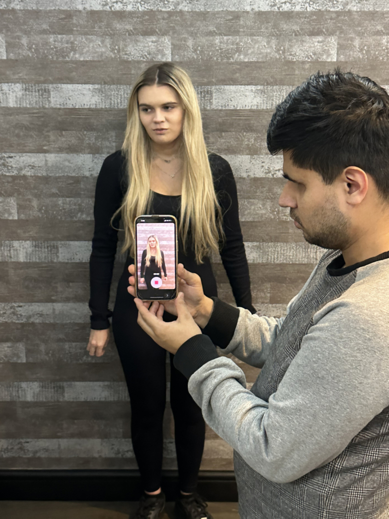 talha-filming-ellie An action shot showing a Changemakers filming another on the phone as they talk to screen.