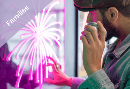 Families. Man looking at and touching a neon pink glowing firework light art exhibit.