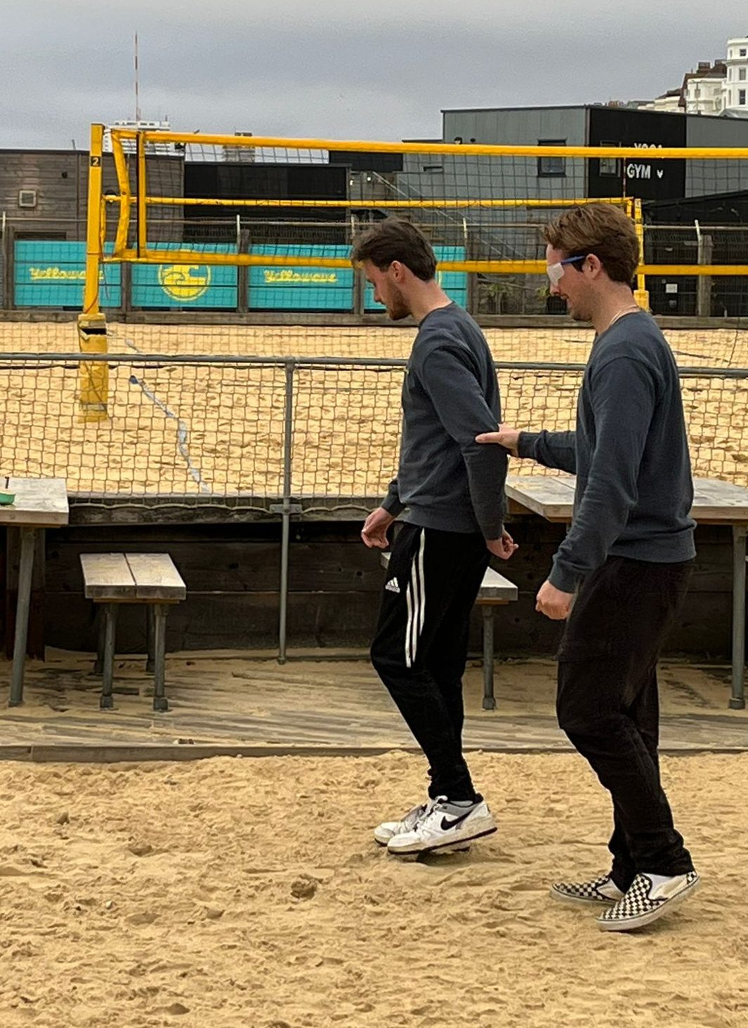 Members of staff guide each other across the sand