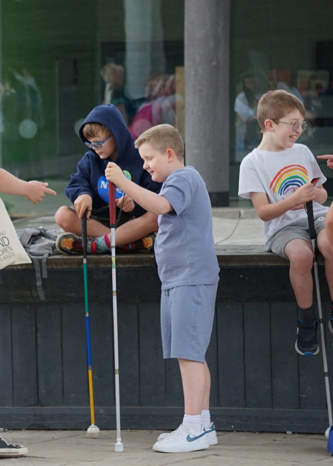 Boys talk while holding their white canes