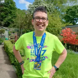 Mags smiles with a medal around their neck