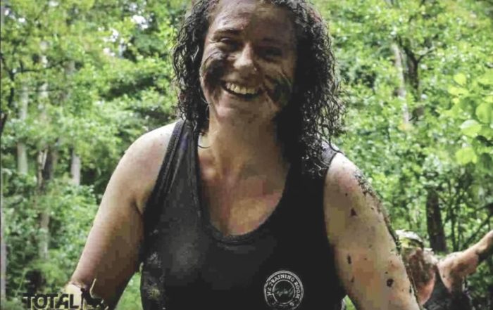 Philip smiles - she is on a Total Warrior run and is covered in mud on her face and hair.
