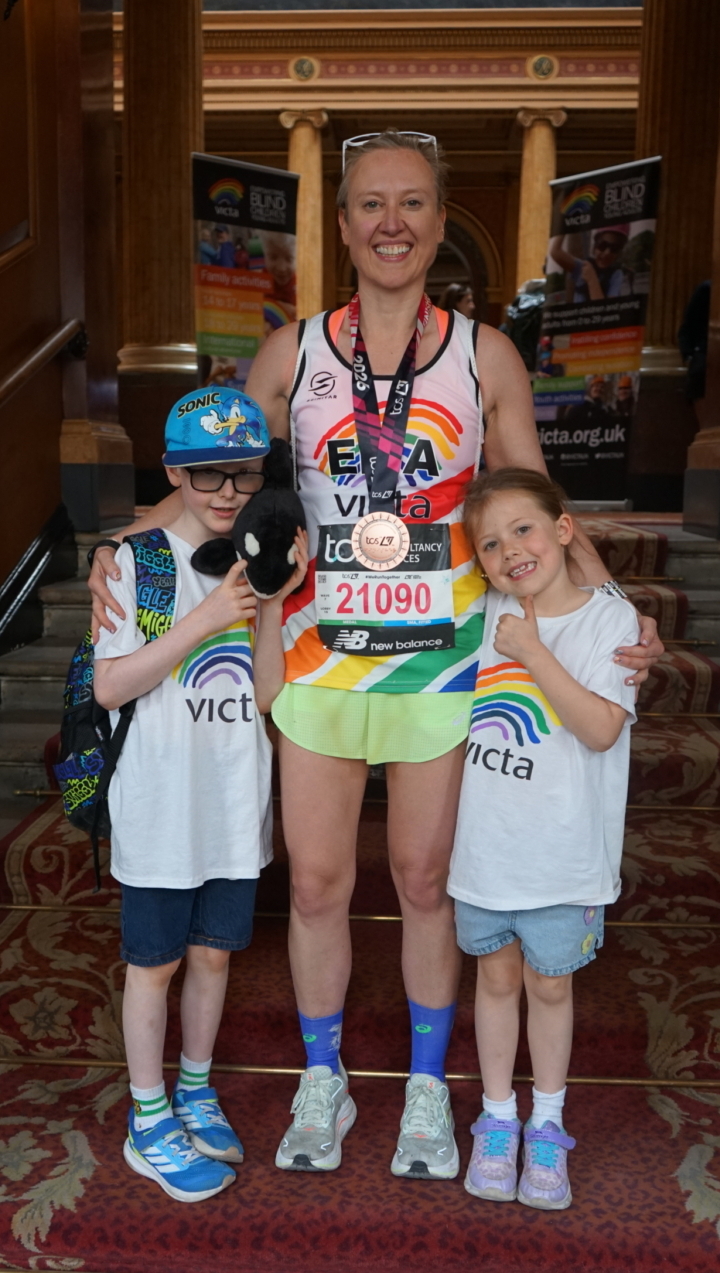 DSC00648 Ema stands at the entrance to the post-race reception with her two children. She has her medal around her neck.