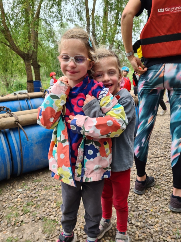 Raft Building (1) Two vision impaired children hug and smile at a raft building activity