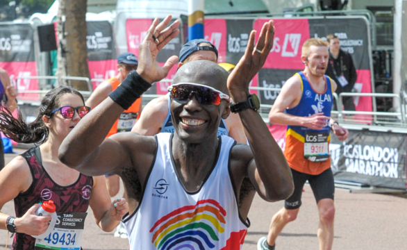 returning-runners-feature A runner cheering in his rainbow vest at the finish
