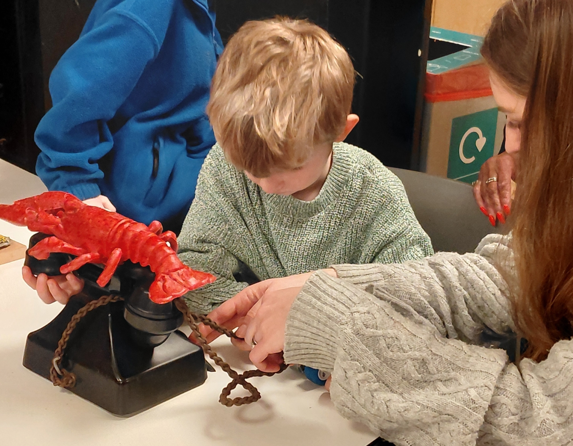 Touch tour feeling a replica of Dali's phone with a lobster on the top