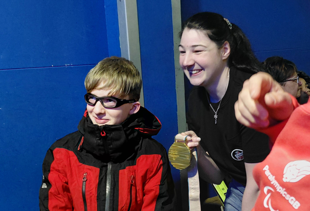 Menna Ski Participant and Medal-crop Menna smiles with a participant while holding out her gold medal at the snow sports day
