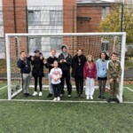Group shot smiling in a football goal